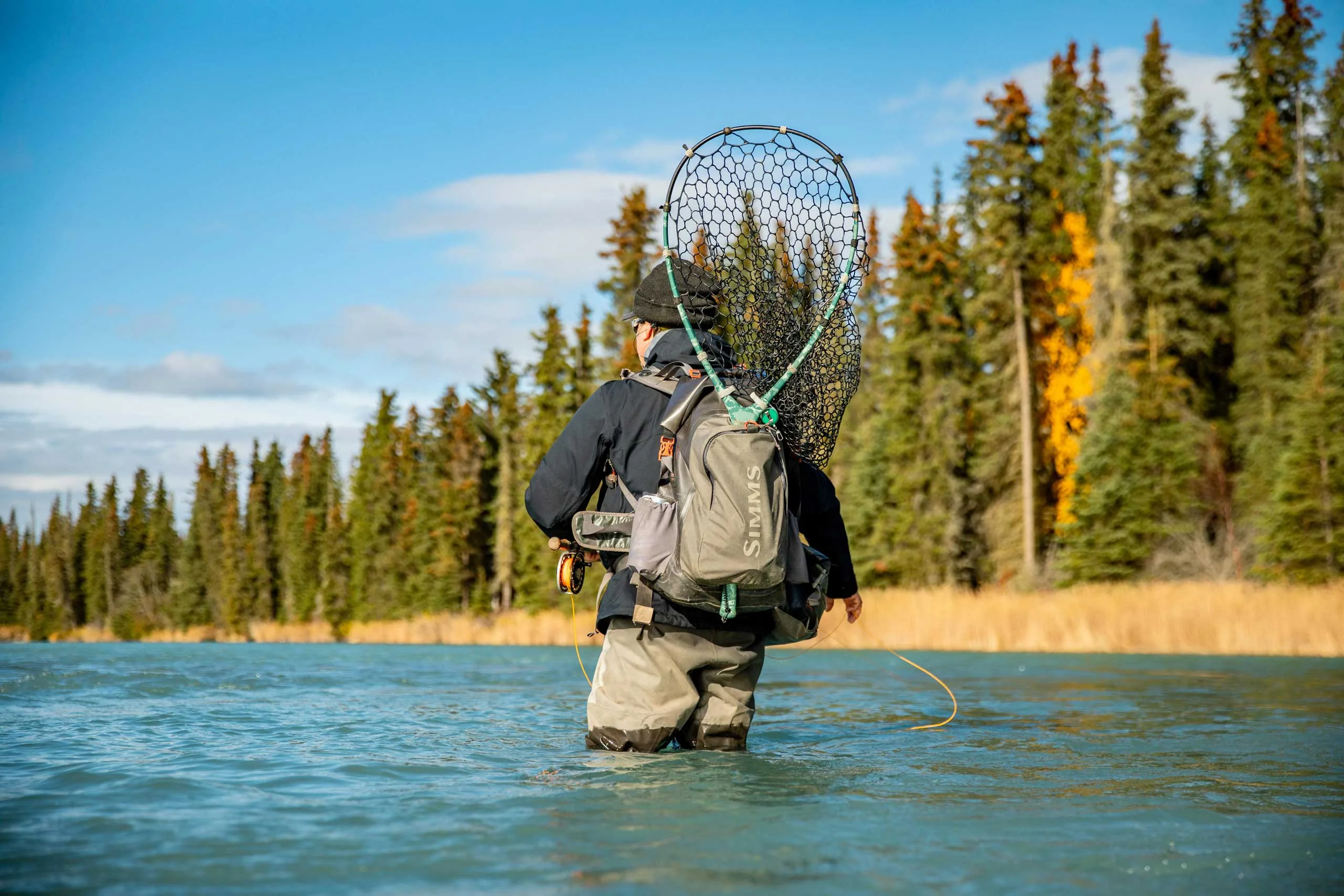 Angler wading with net on a Kenai Peninsula river